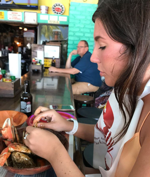 woman eating crab with a bib on